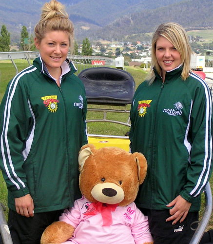 Tassie Spirit Netball team reps (L-R) Kater Schwartz and Natalie Aulish with thye Go The Pink Dog bear mascot aboard a sulky at today's official launch
