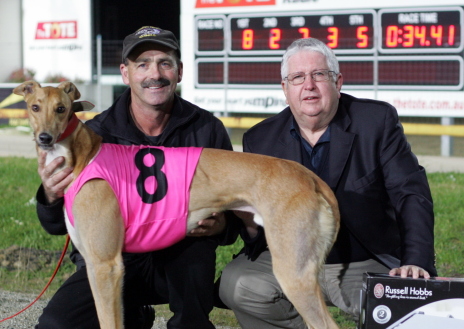 Pudzianowski with trainer Russell Watts and race sponsor Greg Fahey after the dog's impressive win in the Middle Distance Championship at Tattersall's Park on Thursday night
